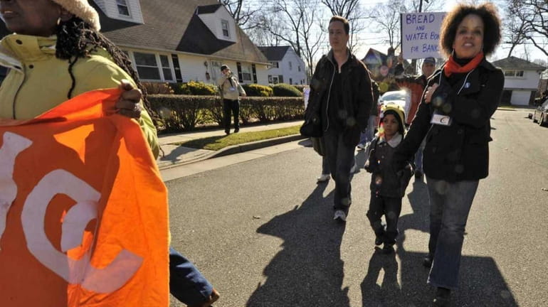 Elmont resident Mimi Pierre-Johnson, right, and her son, Aaron, marched...