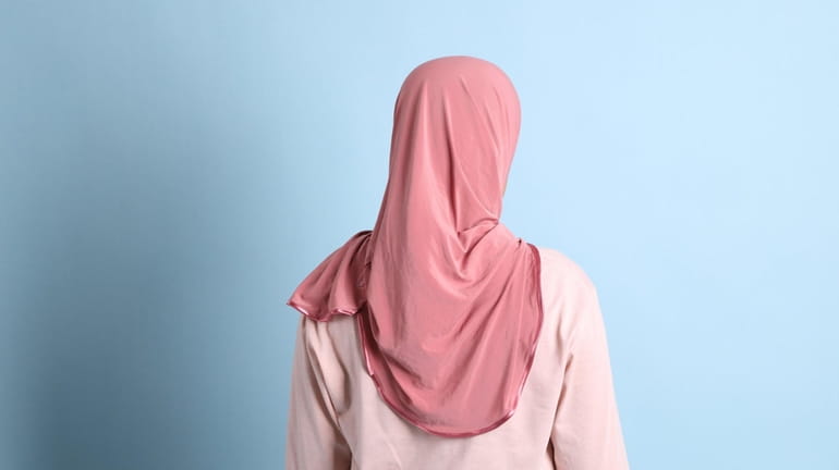 A photograph shows a woman wearing a hijab.