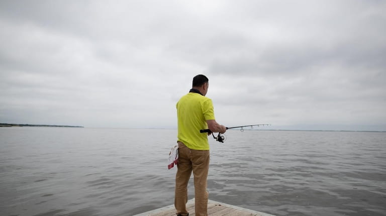 Douglas Gelman of Coram casts a fishing line at the...