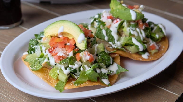 Chicken tostadas are topped with lettuce, salsa fresca and avocado...