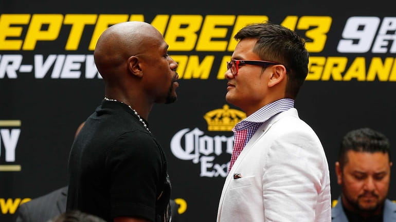 Marcos Maidana and Floyd Mayweather Jr. face off during a...