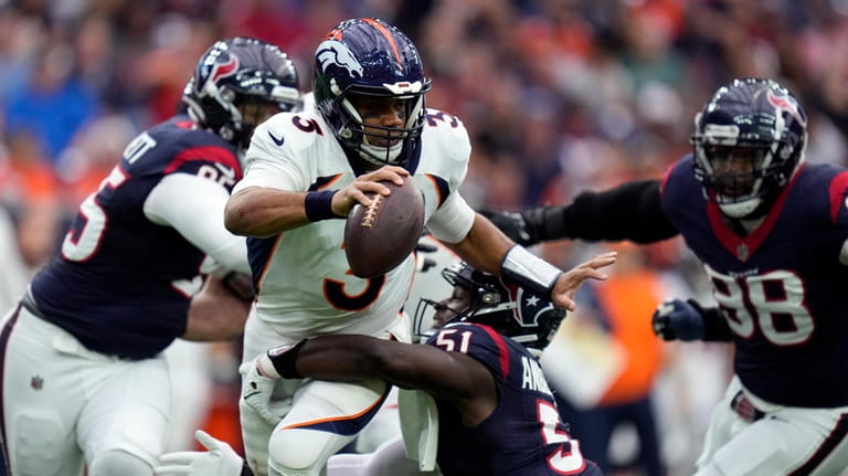 Denver Broncos quarterback Russell Wilson (3) is sacked by Houston...