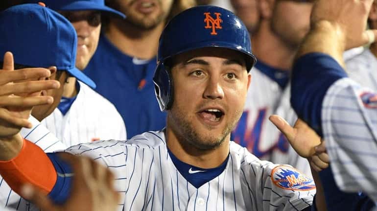 New York Mets rightfielder Michael Conforto is greeted in the...
