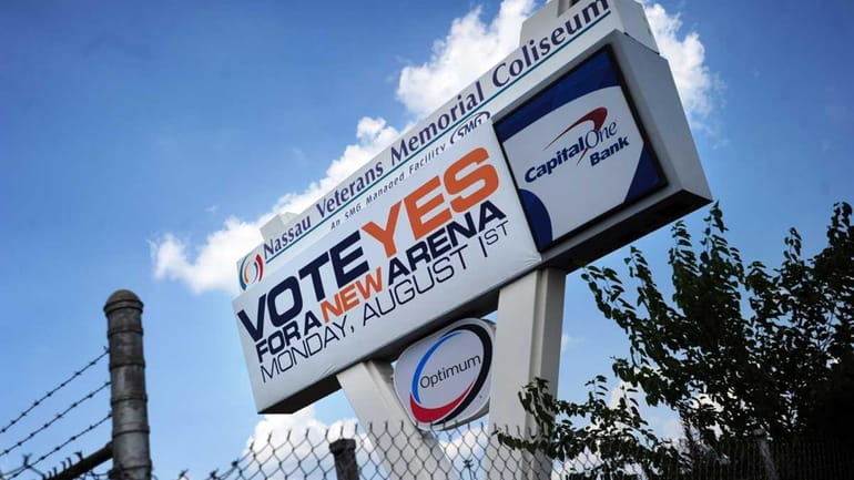 A sign stating "VOTE YES FOR A NEW ARENA" covered...