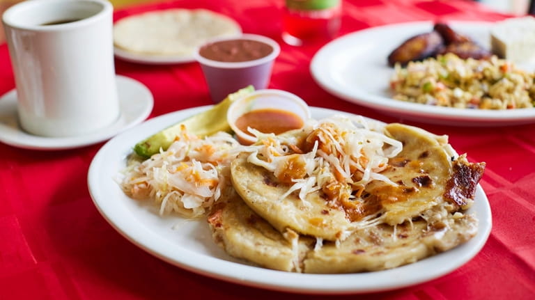 Two pupusas with queso and pork served with curtido and...