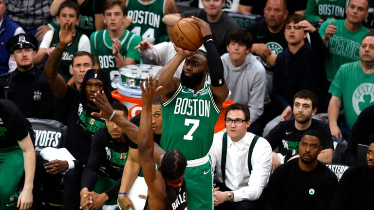 Boston Celtics guard Jaylen Brown, top, shoots as Miami Heat...