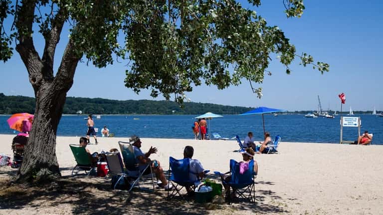 Visitors find some shade at Theodore Roosevelt Memorial Beach in...