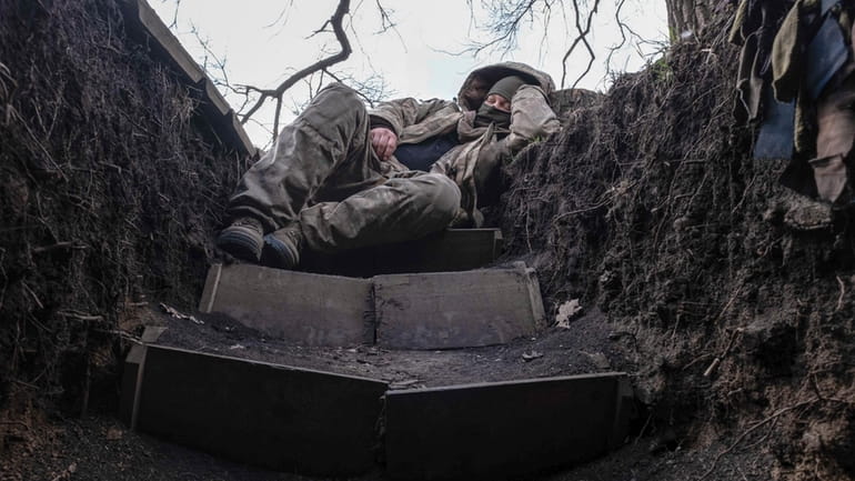 A Ukrainian soldier takes a rest in a trench on...
