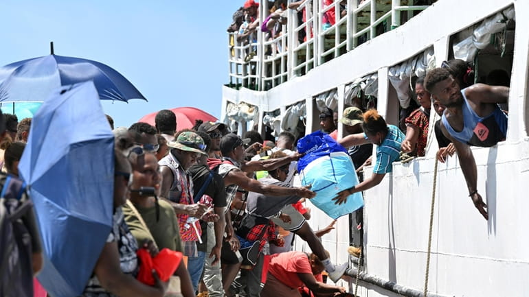 Voters board the already overcrowded Fair Glory ferry in Honiara,...