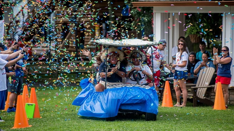 Camp directors ride around on a golf cart as confetti...