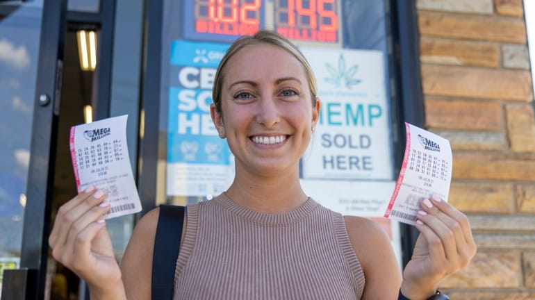 Danielle Hyatt, 27, of Wantagh, holds two Mega Millions tickets she...