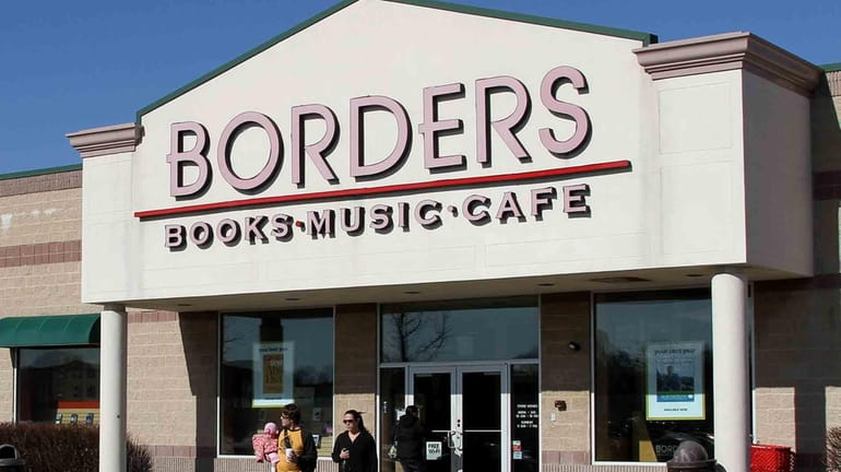 Customers walk out of a Borders bookstore that is slated...
