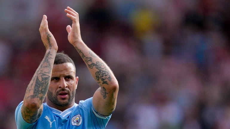Manchester City's Kyle Walker greets fans at the end of...