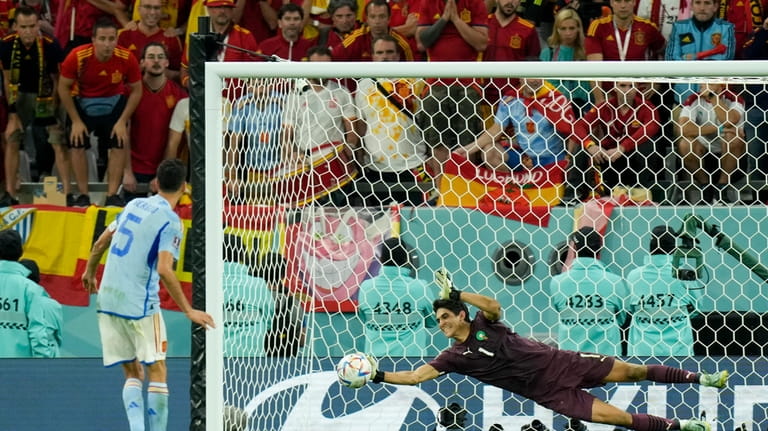 Morocco's goalkeeper Yassine Bounou stops a penalty shot by Spain's...