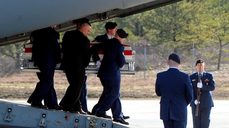The coffin of Staff Sgt. Louis Bonacasa is carried off...