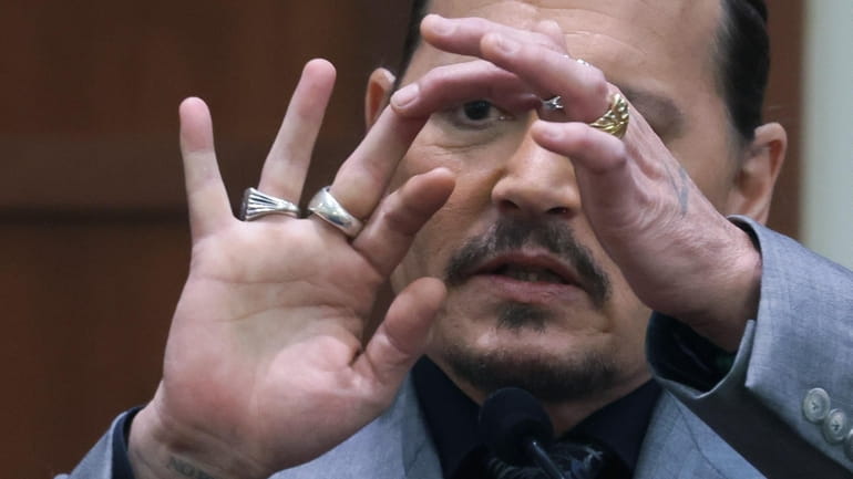 Actor Johnny Depp displays the middle finger of his hand,...