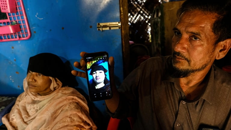 Abdu Shukkur shows a photo of his daughter, Setera Begum,...