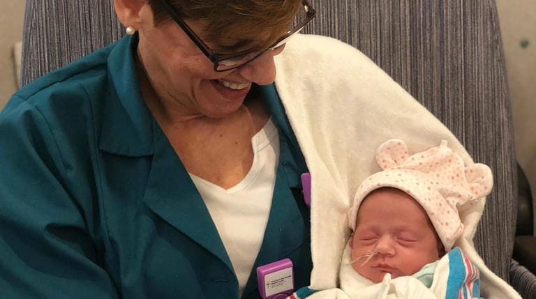 Volunteer Baby Cuddler Laurinda Lundy, 59, of Northport, holds 3-week-old Katrianna...