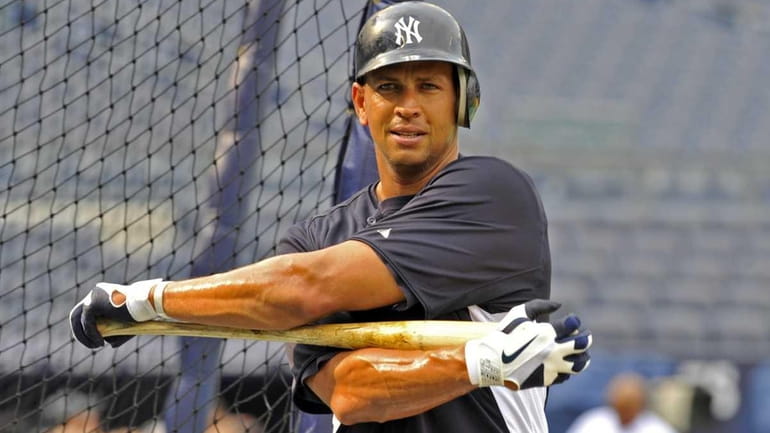 Alex Rodriguez stretches out his upper body around the batting...