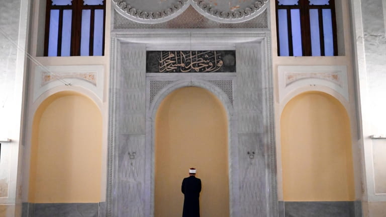 Taha Abdelgalil, the imam who leads the prayer, stands at...