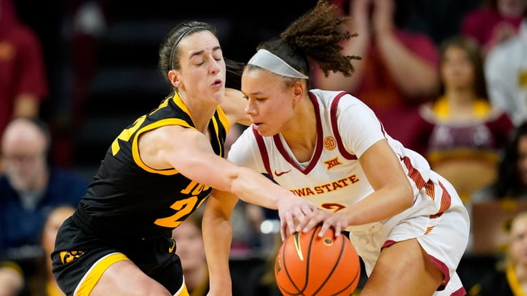 Iowa guard Caitlin Clark, left, tries to steal the ball...