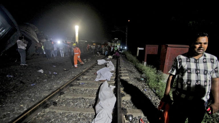 Bodies recovered from passenger trains lay on the track at...
