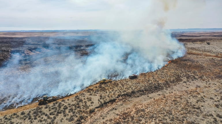 Firefighters battle the Smokehouse Creek Fire north of Canadian, Texas,...