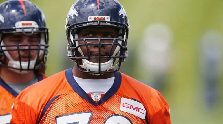 Tackle Ryan Clady waits to take part in drills during...