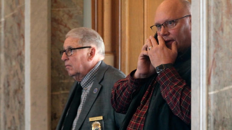 Kansas Republican Party Chairman Mike Brown, right, watches and works...