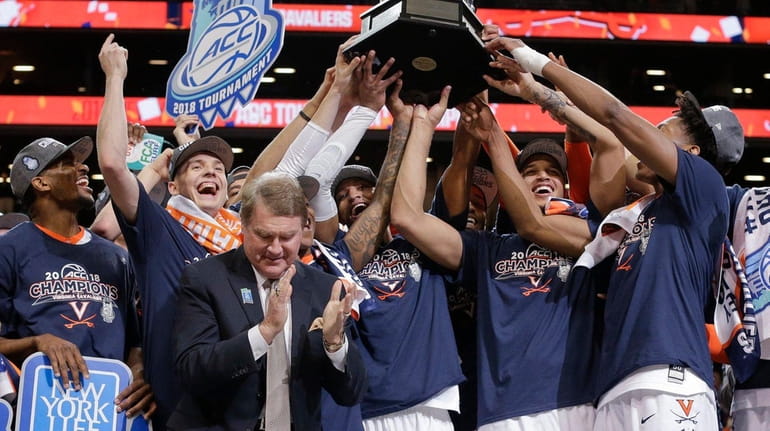 Virginia players celebrate with the championship trophy after defeating North...