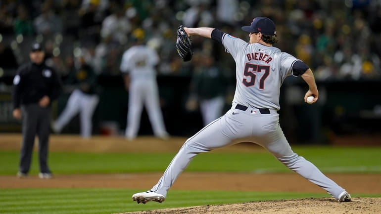 Cleveland Guardians pitcher Shane Bieber throws to an Oakland Athletics...