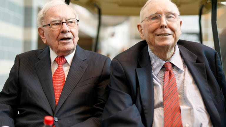 File - Berkshire Hathaway Chairman and CEO Warren Buffett, left,...