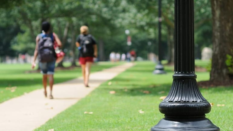 Students walking through a college campus.