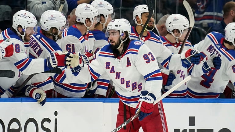 Rangers center Mika Zibanejad celebrates with the bench after his...
