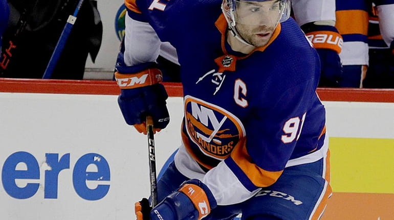 Islanders center John Tavares moves the puck to center ice...