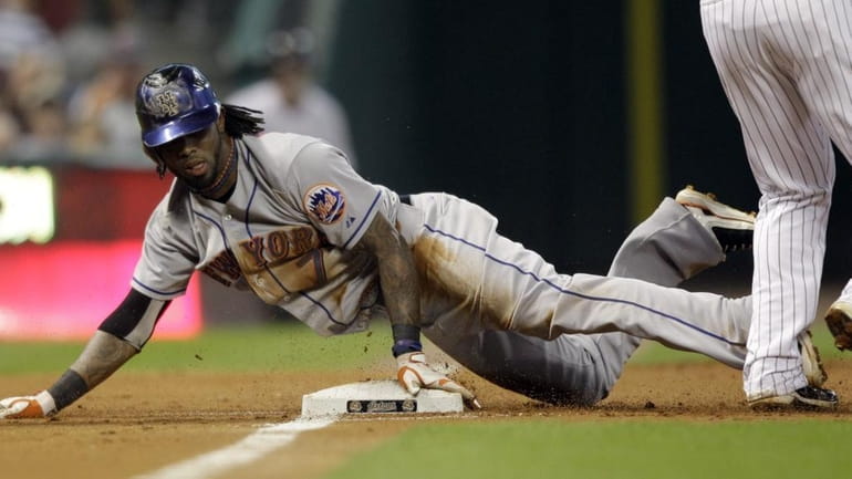 New York Mets' Jose Reyes (7) slides into third base...