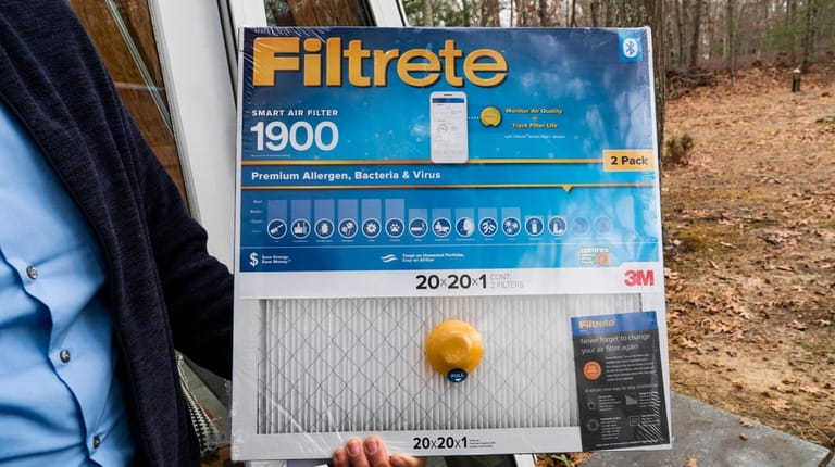 Gordian Raacke holds his Filtrete 1900 smart air filter which connects...