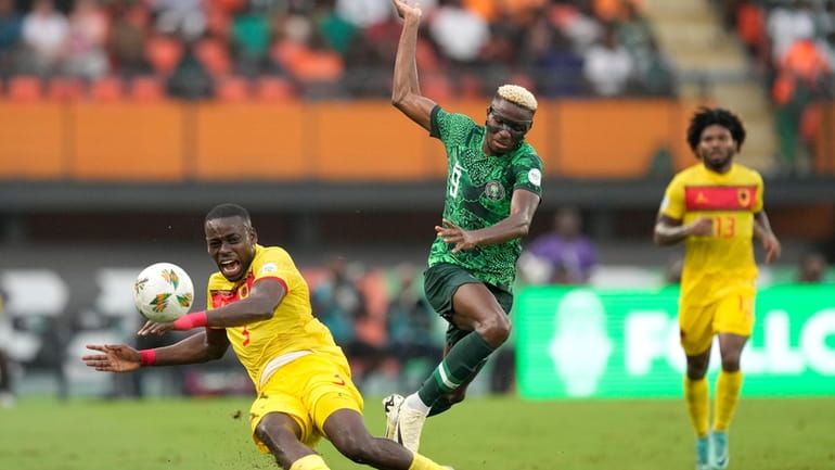 Nigeria's Victor Osimhen, right, challenges Angola's Jonathan Buatu during the...