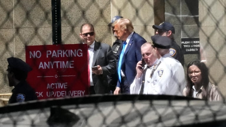 Former President Donald Trump, center, leaves Manhattan criminal court, Monday,...