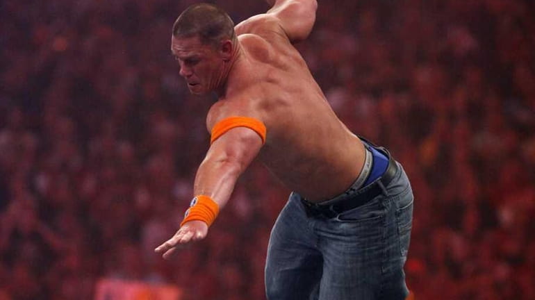 WWE Superstar John Cena, leaps off the top rope against...