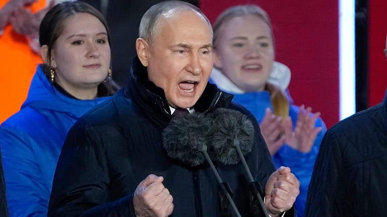 Russian President Vladimir Putin gestures while addressing a crowd at...