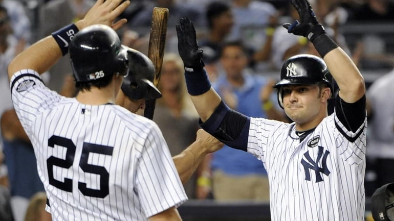 New York Yankees' Nick Swisher, right, is greeted by Mark...