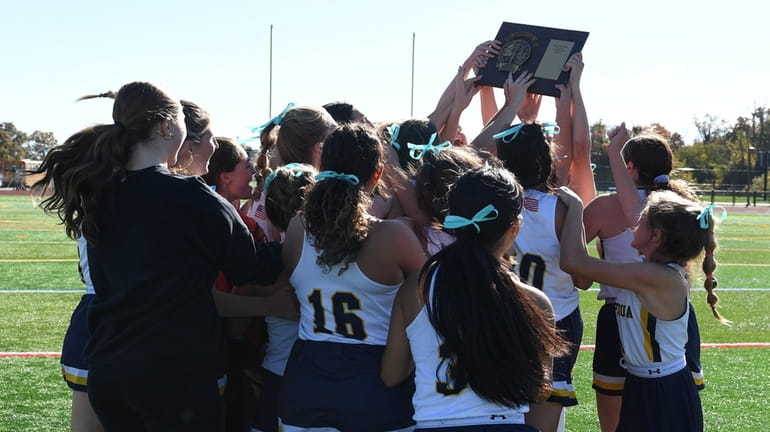 Massapequa players celebrate with their championship plaque after their 5-1...