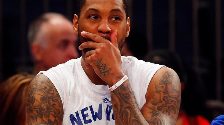 Carmelo Anthony of the Knicks looks on from the bench...