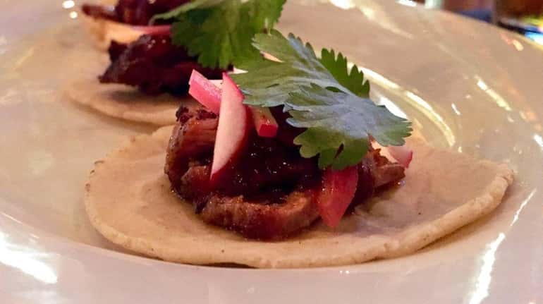 Tacos filled with braised pork is among the small plates...
