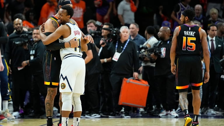 Denver Nuggets guard Ish Smith, right, hugs Phoenix Suns forward...
