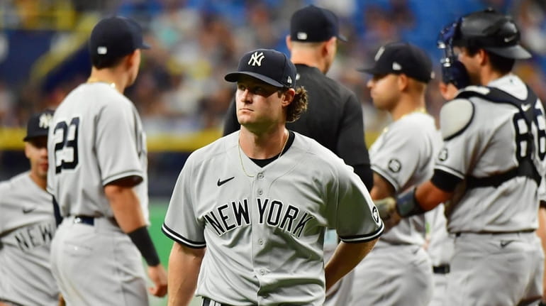 Gerrit Cole #45 of the Yankees walks to the dugout after...