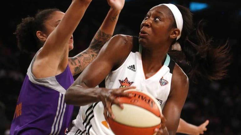 The New York Liberty's Tina Charles, center, is double-teamed by...
