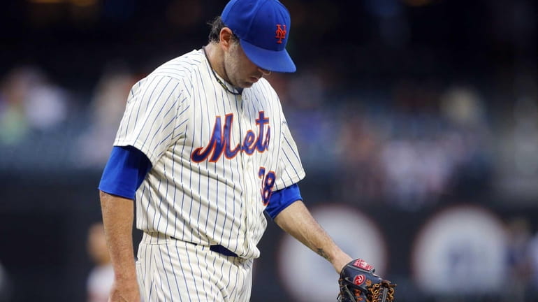 Shaun Marcum of the Mets walks to the dugout after...