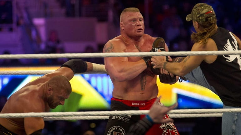 Triple H (with Shawn Michaels) and Brock Lesnar (with Paul...